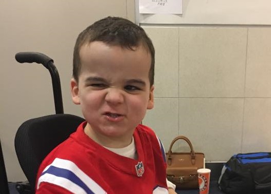Boy with Smith-Kingsmore syndrome with cute, tough look on face