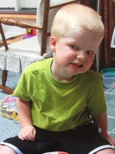 Young child with Smith-Kingsmore syndrome smiling