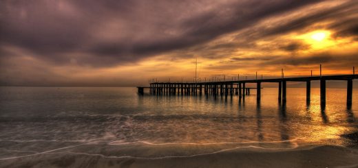 dock by ocean at sunset