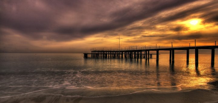 dock by ocean at sunset