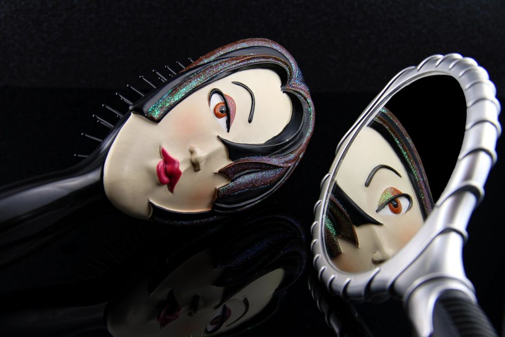 Hairbrush with face painted on it and mirror