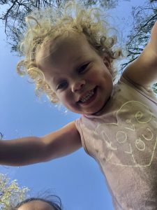 Girl with Smith-Kingsmore syndrome looking down at camera